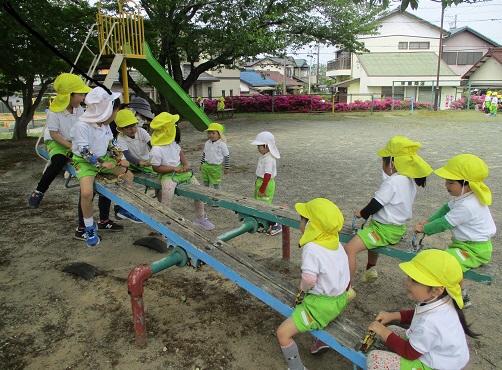 ４歳児が友達とシーソーをしているところ